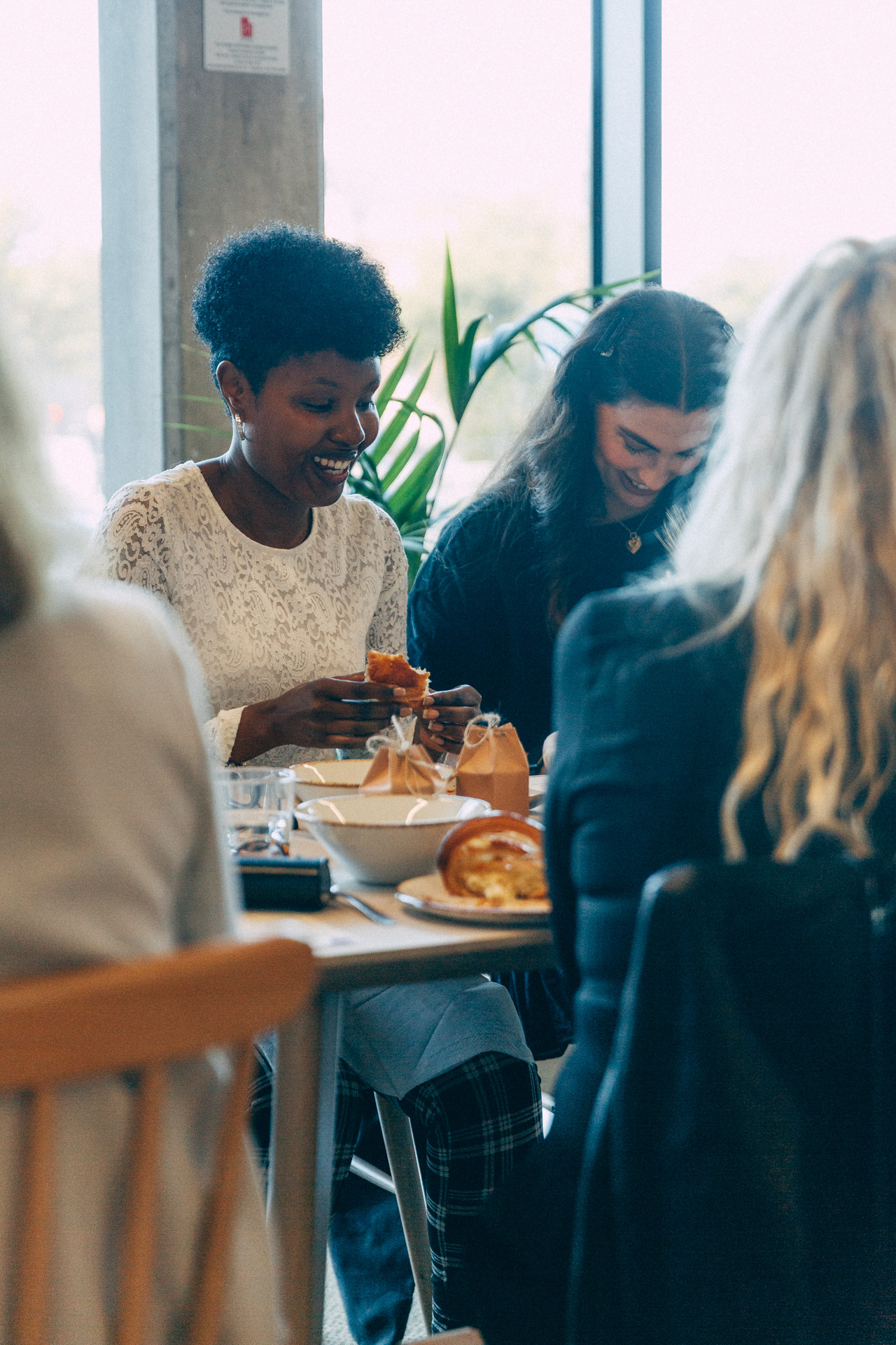 Two women laughing together over breakfast at an EmpowerHER gathering
